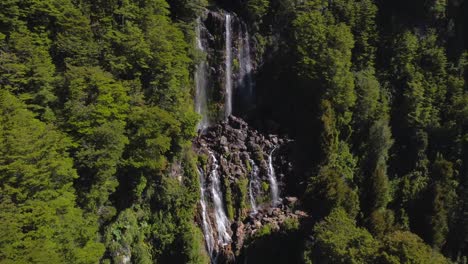 waterfall on cliff between leafy and humid
forests