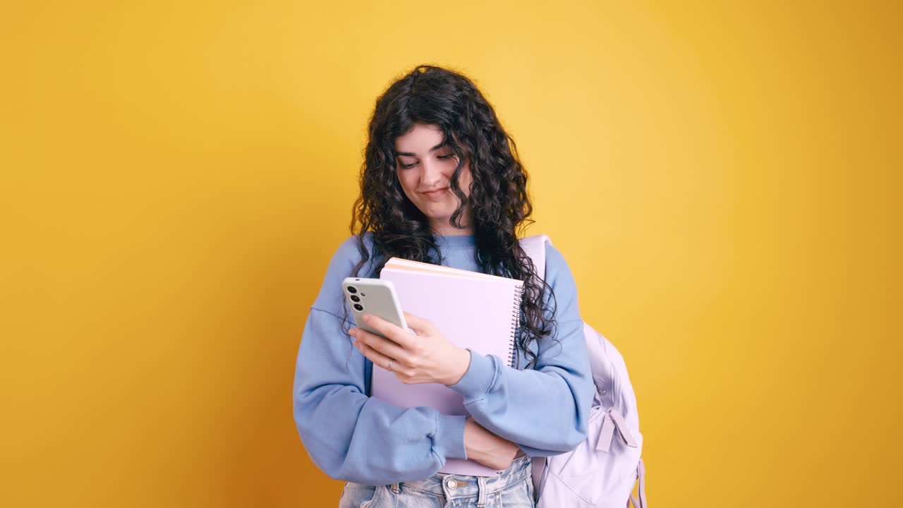 Giovane donna che usa lo smartphone con blocco note e zaino