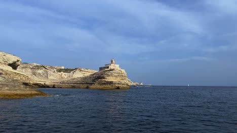 Punto-De-Vista-De-La-Superficie-Del-Mar-Del-Famoso-Faro-De-Madonnetta-Construido-Sobre-Roca-En-La-Isla-De-Córcega-Del-Sur-Visto-Desde-Un-Barco-Turístico