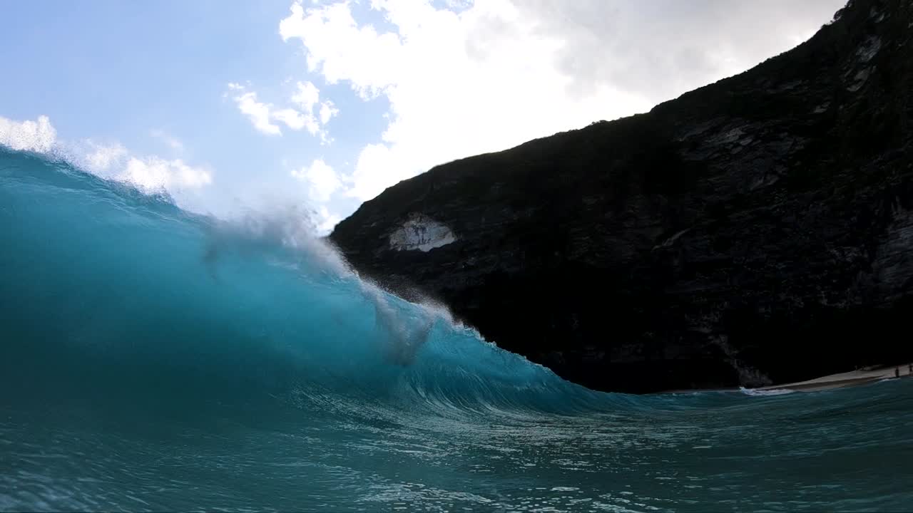 toma en cámara lenta extrema de estar dentro del barril de una gran ola en la playa de kelingking, en la isla de nusa penida, bali, indonesia