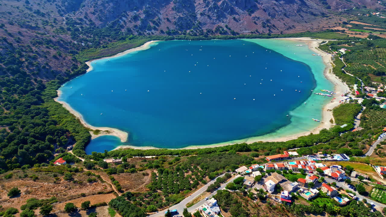 Overlooking Of The Blue Freshwater At Lake Kournas In Crete Island, Greece. aerial, pull-back shot