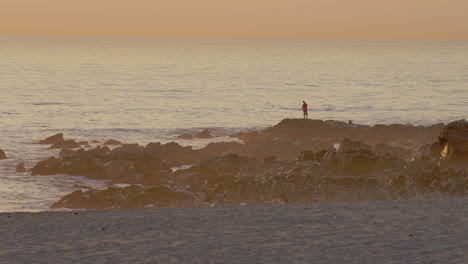 Silueta-De-Un-Pescador-Pescando-En-El-Océano-Durante-El-Amanecer