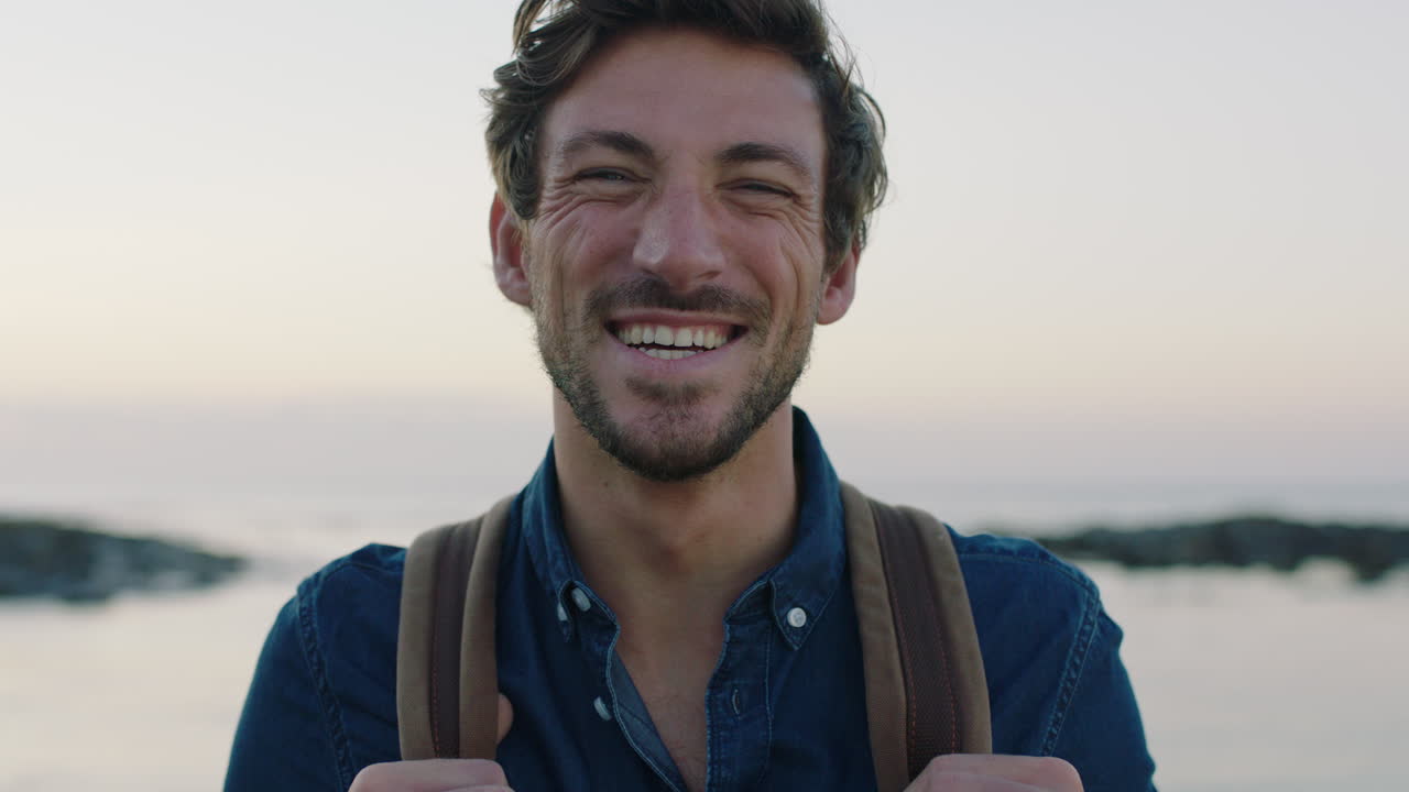 retrato de um homem caucasiano bonito e encantador rindo alegremente na praia à beira-mar