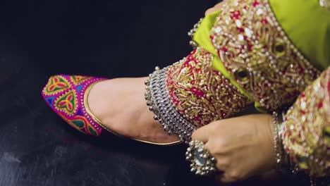 an indian bride from asia who is dressed up for the occasion and has an anklet on her foot