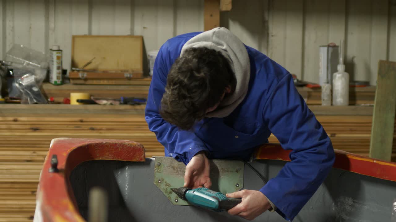 Drilling steel transom plate of fiberglass boat Medium shot