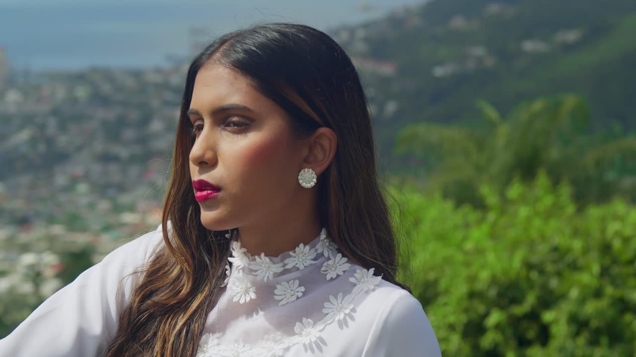 A girl wearing an antique-style wedding dress standing under an archway in a fort.