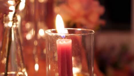 burning candle in a glass container as a table decoration element