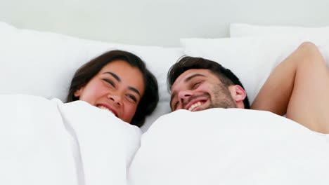 Portrait-of-couple-sleeping-under-white-blanket-on-bed