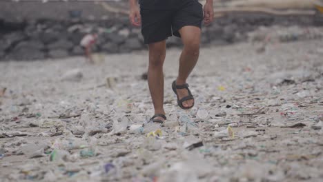 person walking on a polluted beach