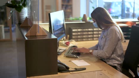 recepcionista - empleado de oficina está tomando algunas notas con máscara facial en el área de recepción - imágenes de turismo de coronavirus