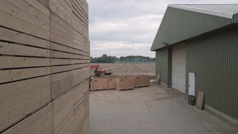 carretilla elevadora que transporta una caja de madera llena de patatas al almacén de patatas