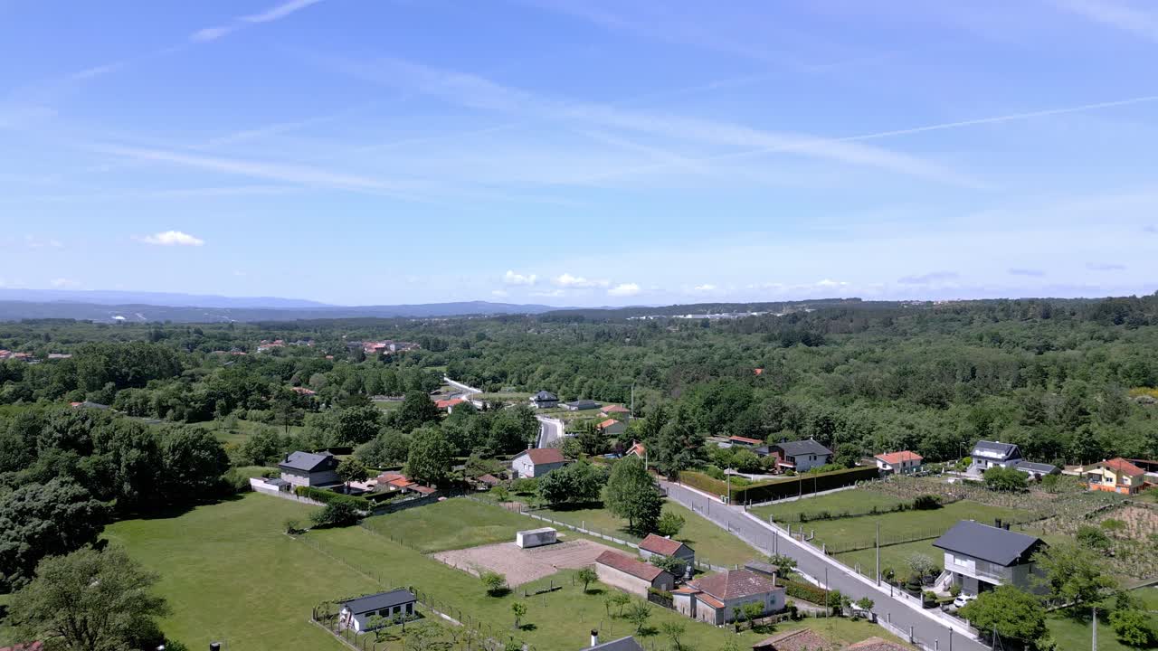 Aerial dolly above peaceful spanish european neighborhood surrounded by tree forest