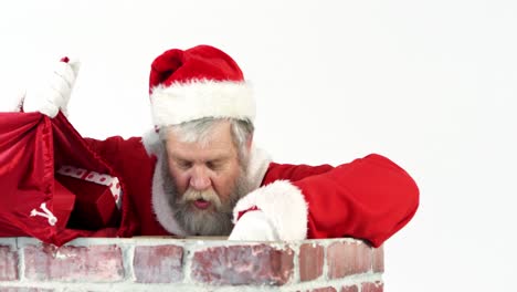 santa claus placing gift box into a chimney