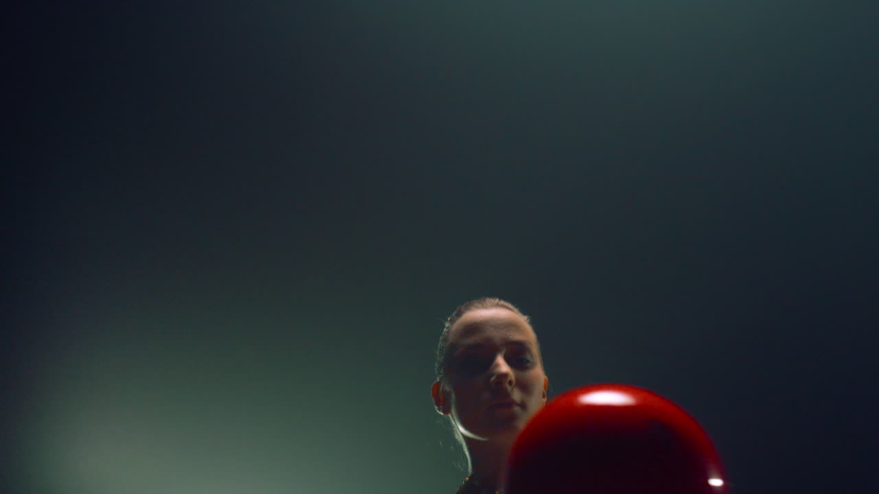mujer hermosa girando la pelota con el dedo levantado. gimnasta rítmica haciendo ejercicio.
