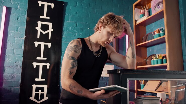 Tatuatore al lavoro nel suo negozio