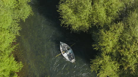 breathtaking bird's eye view of a fishing boat traveling down the chimehuin river in argentina