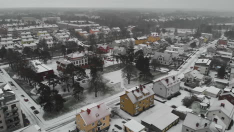 aerial shot of a nordic city during winter in sweden, snow covered houses and streets