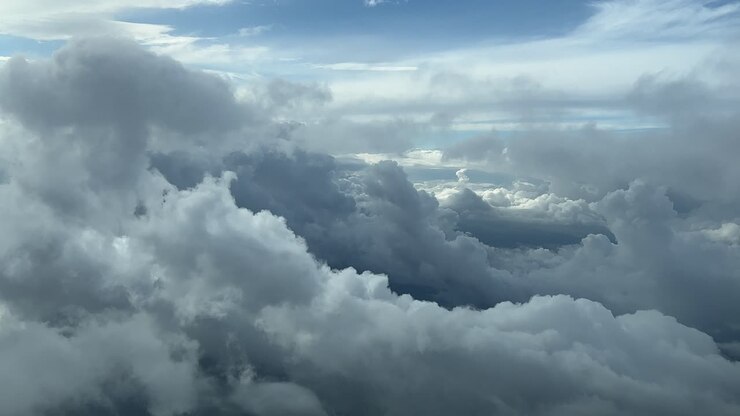 Cloudset shot from an airplane cabin while flying at 5000m high across a sky covered with frayed clouds