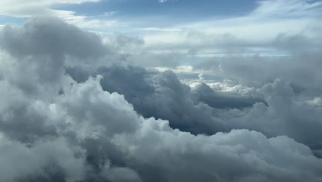 cloudset shot from an airplane cabin while flying at 5000m high across a sky covered with frayed clouds