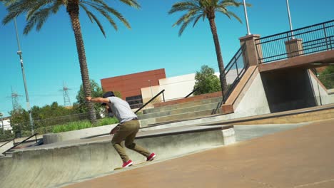 young male skateboarder doing a jump at skate park on skateboard, wide shot slow motion