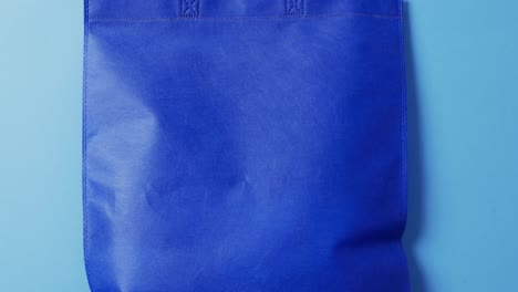 video of blue canvas bag with copy space on blue background