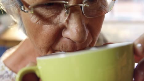 ältere frau trinkt kaffee im café 4k