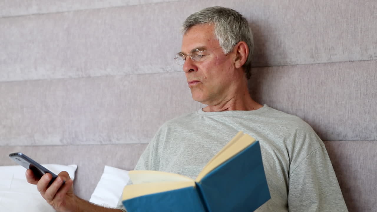 el hombre deja de leer para tomar una llamada.