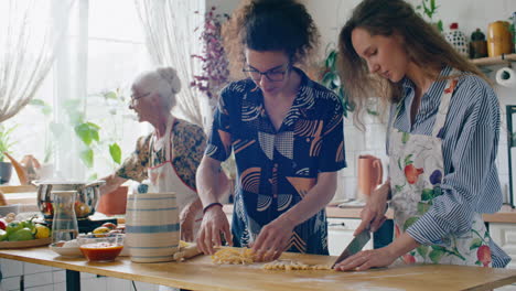 family cooking homemade pasta together in domestic kitchen