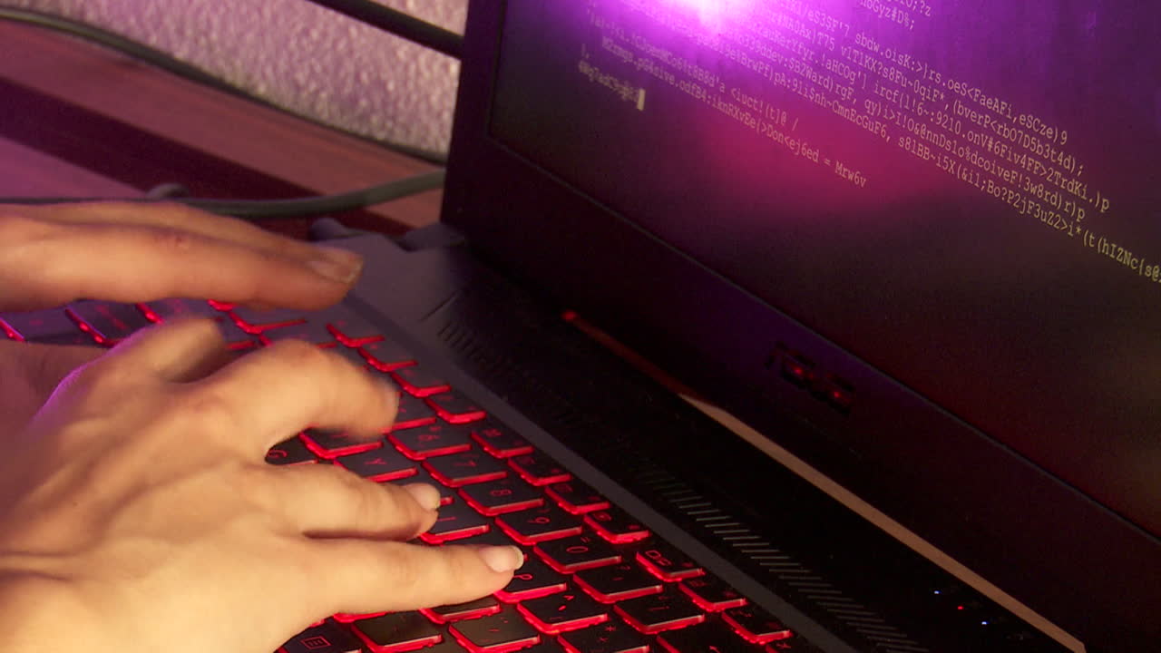 Person Typing on a Laptop with Code on Screen