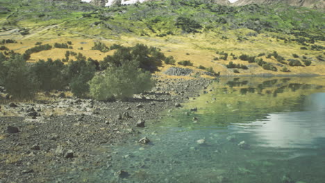 un sereno lago de montaña con aguas azules claras y vegetación verde exuberante