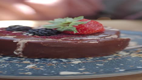 close-up eines schokoladenkuchens mit erdbeeren und schwarzbeeren oben