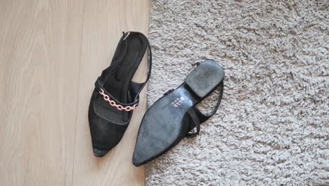 black women's sandals on carpet and wood floor