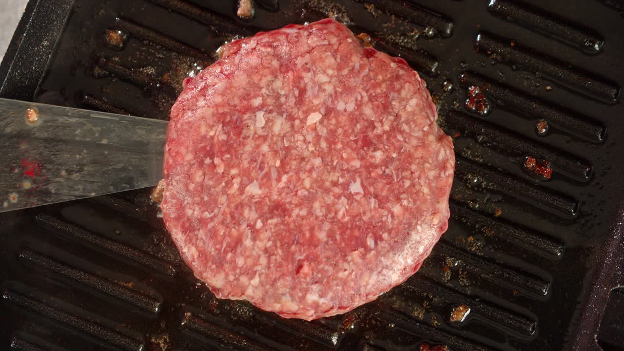 la carne cruda de la hamburguesa se fría en una sartén.