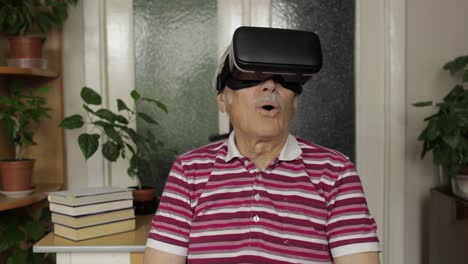 senior grandfather man in virtual headset glasses watching 3d video in 360 vr helmet at home