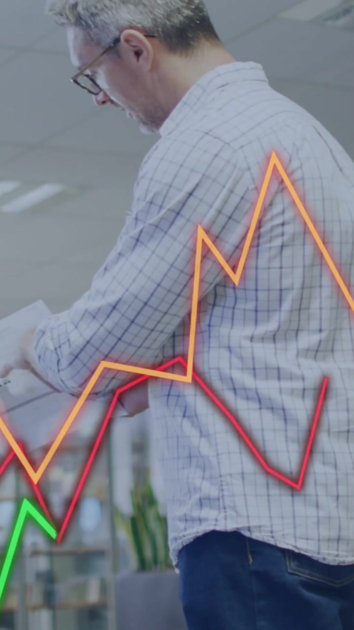 Vertical video: Office man reading docs orange line starting animating market graphs aiding insight