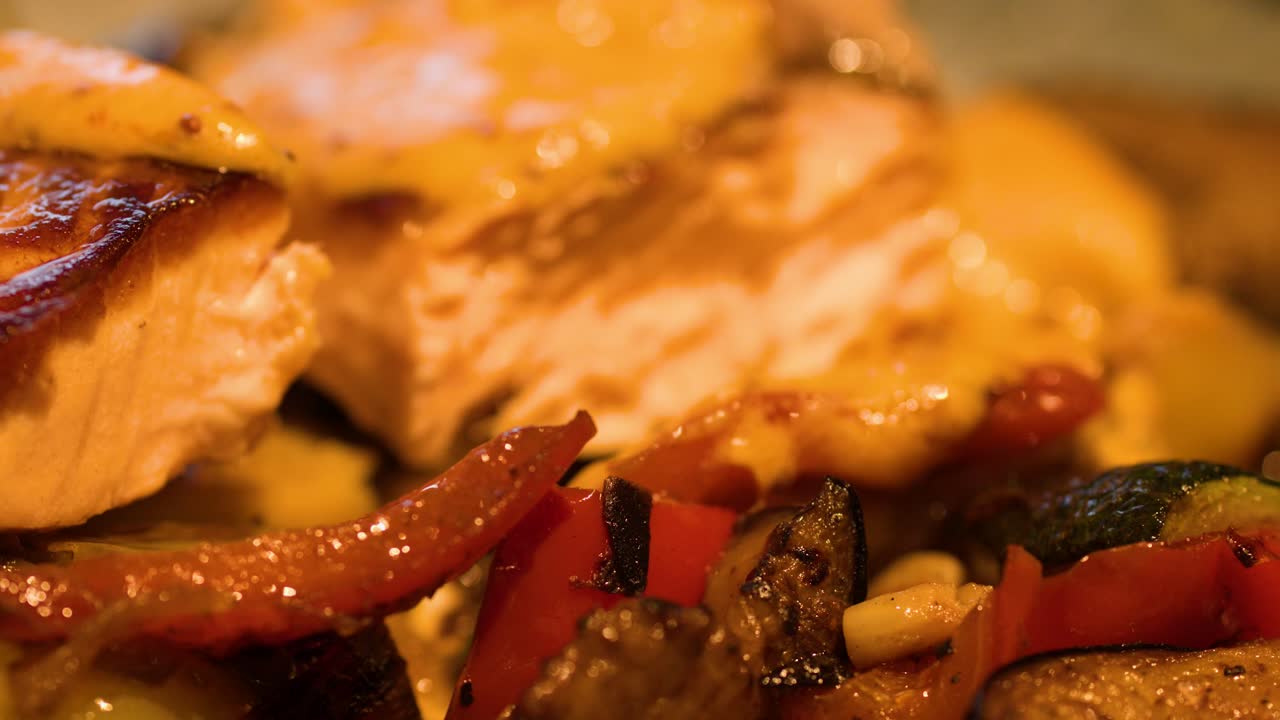 Forchetta taglia filetto di salmone scottato con salsa, disposto sopra un mix di verdure sotto una calda luce ambientale