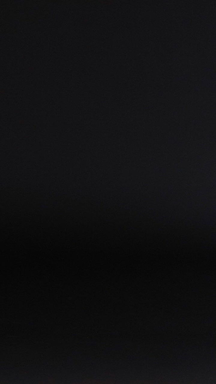 una pelota púrpura rodando a través de una superficie oscura