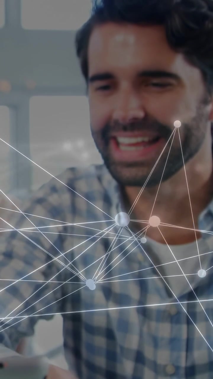 Video verticale: Uomo che tocca un dispositivo su un tavolo di vetro, nodi che tracciano il volto in una demo tecnologica mentre la telecamera si avvicina.