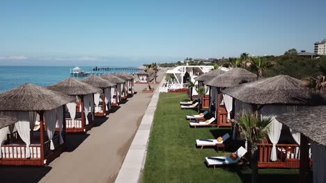 seaside bed houses on sandy beach and green grass in aerial drone