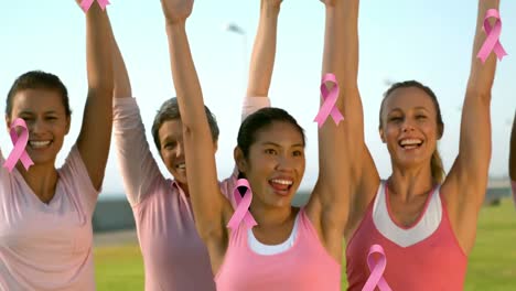 animation of pink cancer ribbons over diverse women raising hands