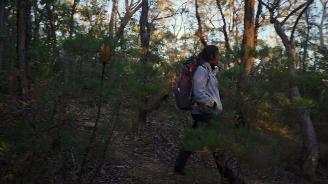 chica indígena australiana de mochila a través de la selva australiana en una mañana fresca de invierno