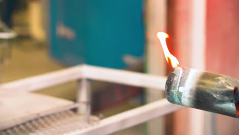 encendiendo un gran soplete de gas con llama caliente azul para calentar el metal