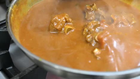preparación del tradicional corma de cordero de hyderabad en la cocina de un restaurante