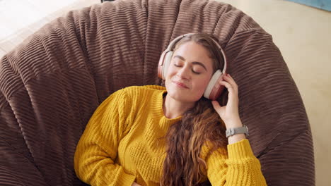 woman relaxing with headphones on a beanbag chair