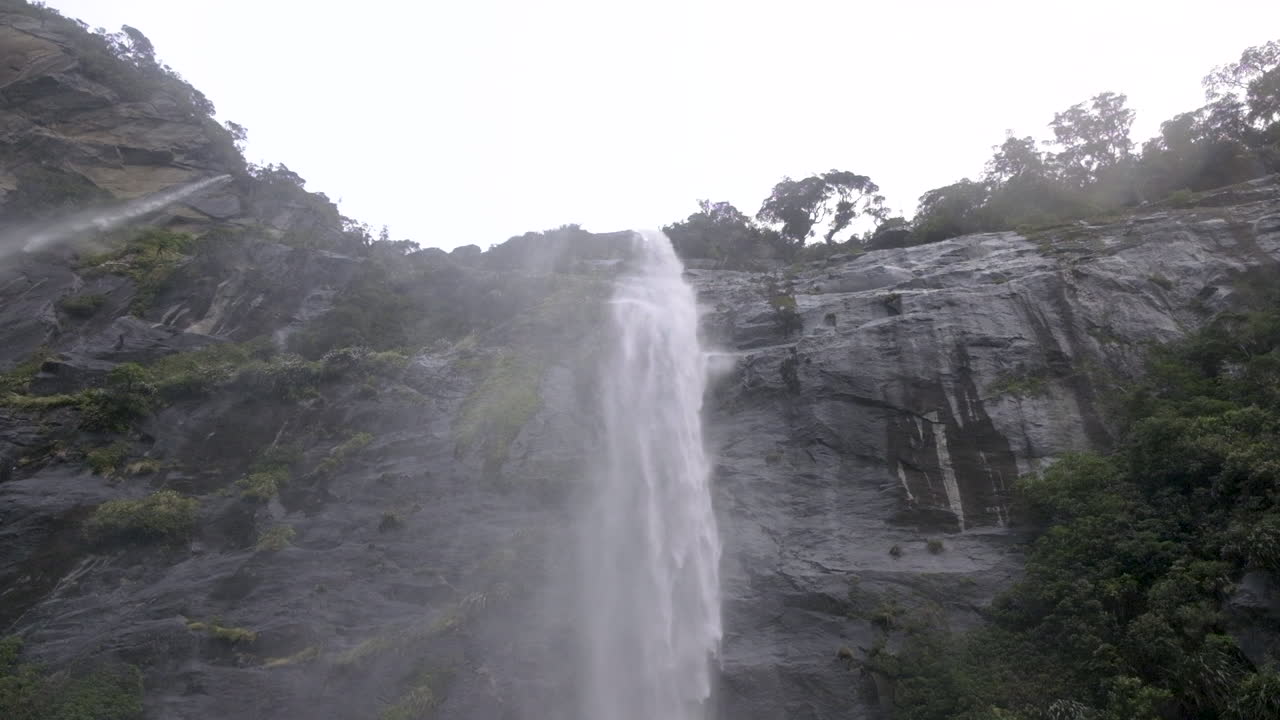 toma en cámara lenta de cascadas que caen por la ladera de una montaña y caen al agua debajo