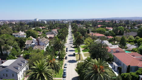 drone zoomt uit om met palmbomen omzoomde straten en herenhuizen in west hollywood, californië, te onthullen