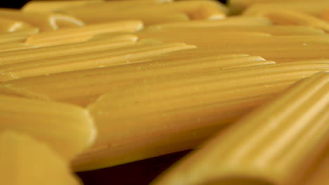 Dolly-Shot-Italienischer-Pasta-Penne-Auf-Einem-Schwarzen-Spiegeltisch