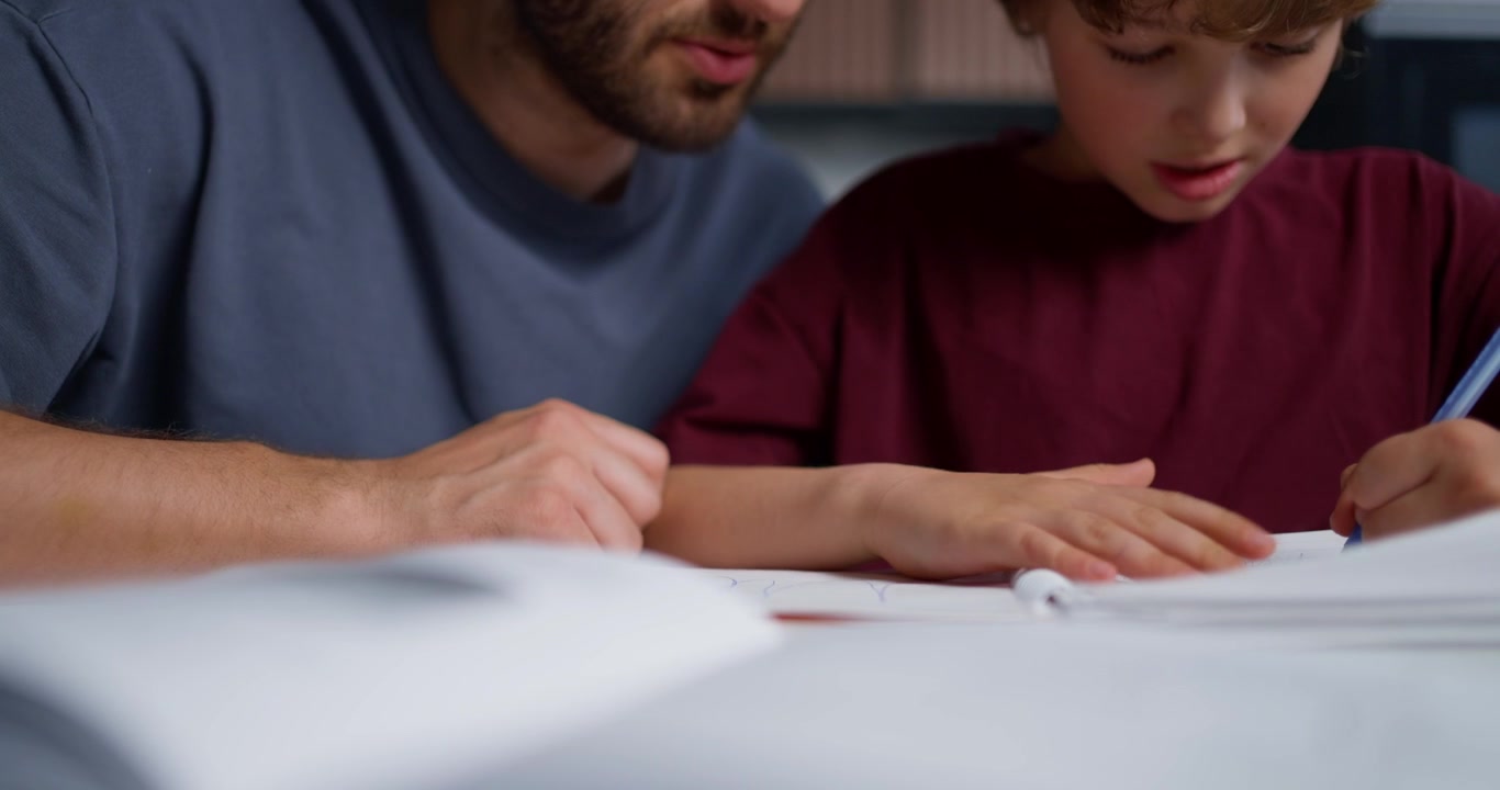 Primo piano di un adulto e un bambino che leggono un libro insieme