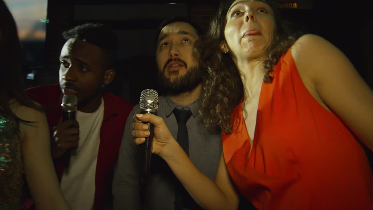 amigos diversos festejando en el club de karaoke