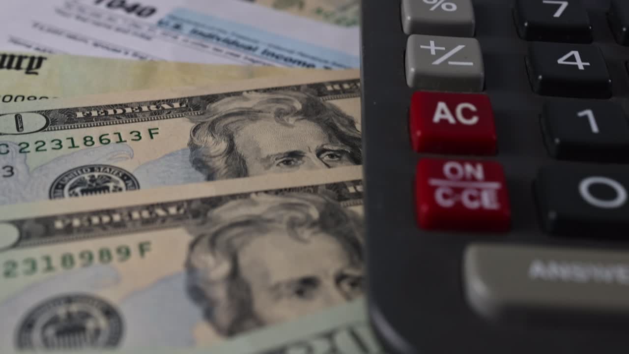 formulario de declaración de impuestos 1040 con la moneda billetes de dólar de estados unidos cerrados